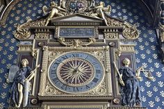 an ornate clock on the side of a building with statues and angels around it's face