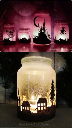 three mason jars with silhouettes of houses and trees in them, one is lit up at night