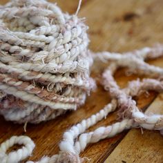 a ball of yarn sitting on top of a wooden floor next to some stringing