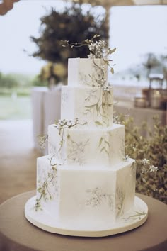 a three tiered white cake sitting on top of a table