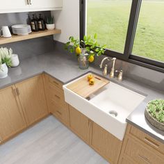 a white kitchen sink sitting under a window next to a counter top with a cutting board on it