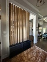 a living room filled with furniture and a window covered in wooden slatted blinds