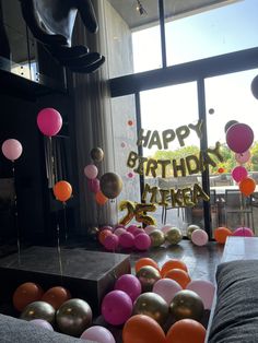 a birthday party with balloons and streamers in front of a window that says happy birthday