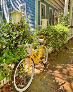 a yellow bicycle parked in front of a blue house