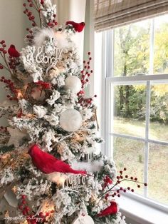 a white christmas tree with red and silver ornaments