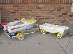 two pedal boats are sitting next to each other on the sidewalk near a brick wall