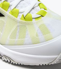 a white and yellow tennis shoe with black laces