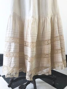 Antique Victorian cotton maxi skirt has horizontal pleats, and lace ribbon insets at the hem. The skirt has clasp closures, and an underskirt at the hem portion of the skirt. ConditionStructurally good, with issues. Has overall yellowing, with darker areas, and stains throughout but most prominently in the hem area. There are tiny dot stains on the upper skirt portion. There’s two area of holes in the lace at the hem.  The underskirt has staining throughout. We have not attempted to clean this i Cotton Maxi Skirt, Lace Maxi Skirt, Cotton Maxi Skirts, Maxi Lace Skirt, Skirt With Lace, Brown Cardigan, Cotton Maxi, Mini Slip Dress, Lace Ribbon