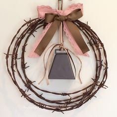 a wreath made out of barbed wire with a bell hanging from the front and side