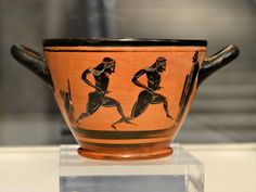 an ancient vase with two women running on it