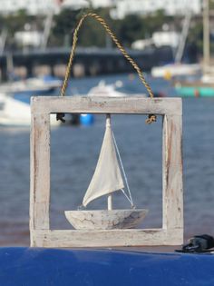 a sailboat is hanging from a wooden frame