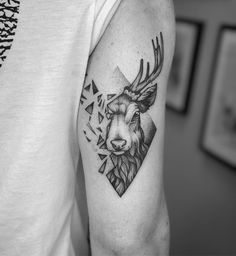 a man with a deer head tattoo on his arm