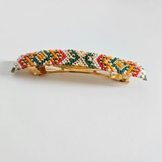 Original barrette in summer colors, 24k fine gold barrette, is the ideal hair jewel to highlight it. The beads are hand-woven with Japanese Miyuki 11/0 beads, the colors of which are gold, white, red, orange and green. This barrette, hand-woven with love, goes easily with any style of clothing; it's a unique and rare piece that you won't find on anyone else. Dare to stand out with unique and elegant accessories. You can also give it to a special person in your life who will be delighted to have Bead Loom Barrette Patterns, Beaded Barrettes, Beaded Hair Barrettes, Seed Bead Hair Clip, Handmade Adjustable Multicolor Hair Accessories, Embroidered Barrette, Wedding Barrettes, Hair Jewels, Elegant Accessories