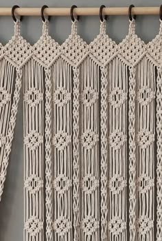 crocheted curtains hanging on a wooden rod