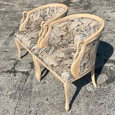 two chairs sitting in the middle of a parking lot with no one around them on it