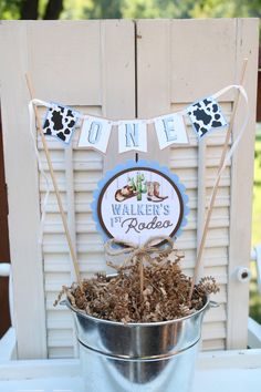 a bucket filled with dirt sitting on top of a wooden table next to a sign