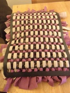 a cake sitting on top of a wooden table covered in pink and white icing