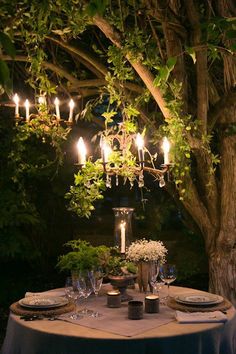 the table is set with candles and plates