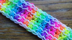 there is a multicolored crochet stitch on the edge of a piece of wood