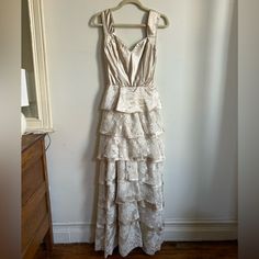 a white dress hanging up against a wall