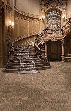 an ornate staircase in the middle of a large room with wood paneling and chandeliers