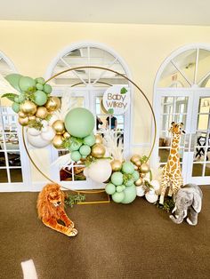 an animal themed baby shower with balloons and animals on the floor in front of it