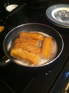 fried food being cooked in a frying pan on top of an electric stovetop