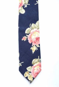 DESCRIPTION: This lovely men's skinny tie has been handmade using a beautiful vibrant pink floral print on navy blue linen. Please be aware that each tie purchased may vary, this is due to the large placement of the print.FABRIC: Linen.LINING FABRIC: Cotton.--------------------------------------------------------------------------------------------DETAILS:• Made the traditional way with fabric cut on the bias• Each tie has canvas lining throughout• Fabric lining just at the tip on each end of th Summer Floral Print Ties, Classic Floral Print Ties For Summer, Classic Floral Print Ties, Classic Floral Print Summer Tie, Elegant Floral Print Summer Ties, Elegant Summer Floral Print Ties, Classic Floral Print Tie For Gift, Classic Floral Print Tie As A Gift, Classic Floral Print Ties As Gifts