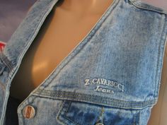 Quality 1980's brand Z.Cavaricci denim vest. Thick and sturdy ladies, juniors size vest. Faded blue denim, designed with detail and style. 2 usable pockets on each side of the upper-chest; button closure. Quality denim, well-made garment. A travel-companion piece, pairing with many items, an extra accessory that works many ways. Urban, with a turtleneck, over a bikini-top, and perfect for hiking with the adorable little pockets. A quality, forever piece. Perfect vintage. Clean. No issues. ready to be adorable in! 'Z.Cavaricci' tag states Large (please note this is Juniors brand which is typically for teens, runs smaller), and the measurements are: 18 inches long (top to bottom), 17 1/4 inches across chest (armpit seam to armpit seam).  https://vintagethisexit.etsy.com Jim Cavaricci launche Z Cavaricci Jeans, Womens Denim Vest, Jeans Vest, 80s Denim, Jean Vest, Juniors Jeans, Faded Denim, Vest Outfits, Denim Vest