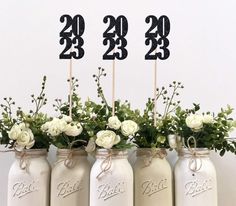 four mason jars with flowers and numbers on them