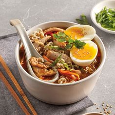 a bowl of ramen with an egg on top and chopsticks next to it