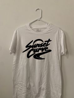 White short sleeve T-shirt with Sunset Curve on the front Screen printed Unisex White Cropped T-shirt With Logo Print, Casual Short Sleeve Shirt With Letter Print, Casual White Printed Shirt, White Print Logo Print Short Sleeve T-shirt, White Short Sleeve T-shirt With Text Print, White Print Logo T-shirt Short Sleeve, Casual White Print Short Sleeve Shirt, White Print Screen Printed Short Sleeve Tops, Short Sleeve Shirt With Graphic Print