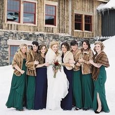 a group of women standing next to each other in front of a snow covered building