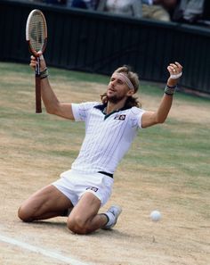 a man kneeling down on the ground holding a tennis racquet in his hand