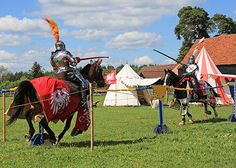 two men dressed in medieval armor riding horses