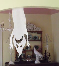 a white bird sitting on top of a wooden table next to a chandelier