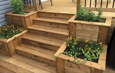 wooden steps with planters and flowers in them on the decking area at a house