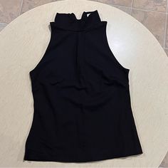 Washed But Never Used. Nice Thick Material. Mock Neck And Sleeveless. Chic Black High Neck Halter Top, Black High Neck Tank Top For Spring, Spring Black High Neck Tank Top, Black High Neck Tank Top For Night Out, Black Stretch Halter Neck Top, Black Tank Top Vest For Workwear, Fitted Sleeveless Black Halter Top, Fitted Halter Neck Top For Work, Black Sleeveless Vest Top