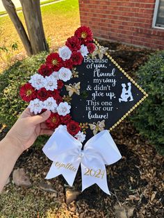 someone is holding up a graduation cap decorated with flowers