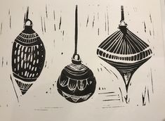 three black and white ornaments hanging from strings