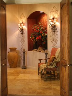 an entry way leading to a living room with vases and flowers on the wall