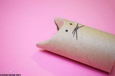 an origami pillow with a cat drawn on it's side sitting on a pink surface