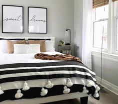 a black and white bed in a bedroom with two pictures on the wall above it