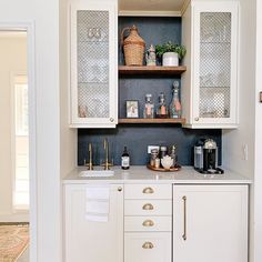 a kitchen with white cabinets and gold pulls on the cupboards is pictured in this image