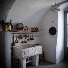 a white sink sitting under a window next to a shelf