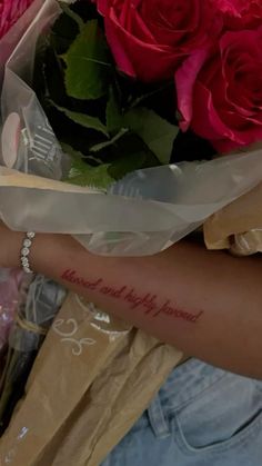 a woman holding a bouquet of roses with the words love and happiness written on her arm