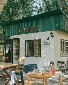 a small white building with tables and chairs outside