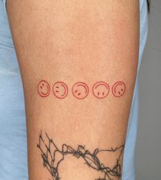 a woman's arm with three smiley faces on it and the word love written in red ink