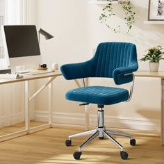 a blue office chair sitting on top of a wooden floor next to a computer desk