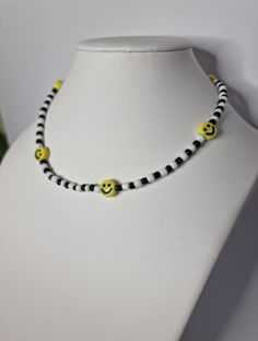 a white mannequin with yellow and black beads on it's neckline